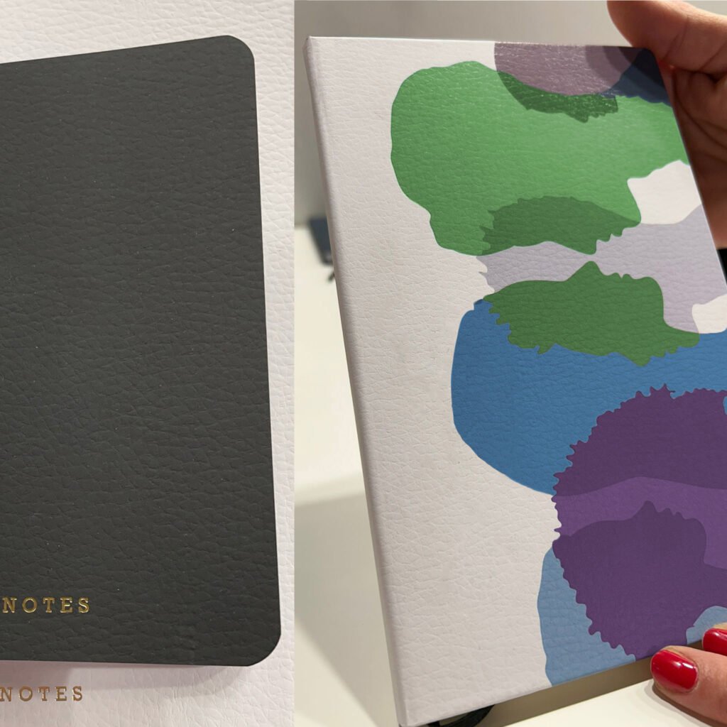 A black and a white fully printed notebooks made with a cardboar that replicate the look and feel of leather